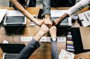fists uniting over a desk